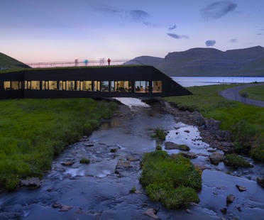Henning Larsen的混凝土和木材市政厅在河上的一座桥上